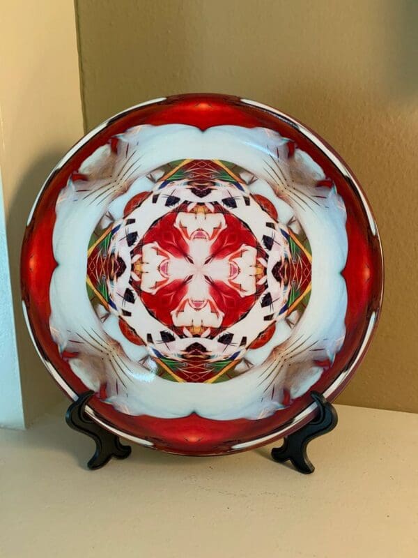 A decorative plate with a red and white design on it.