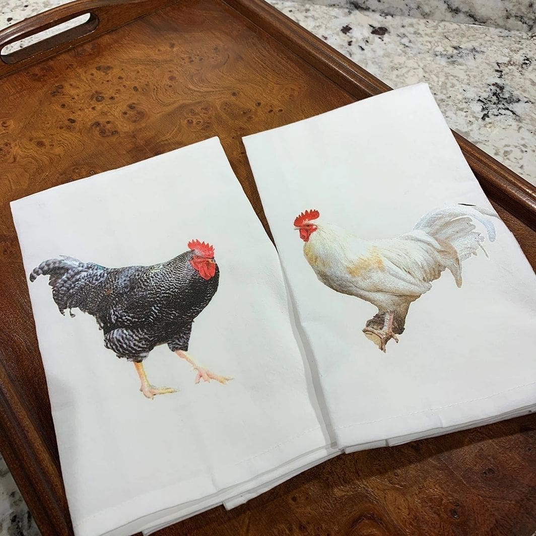 A tray with two towels and one towel has chickens on it.