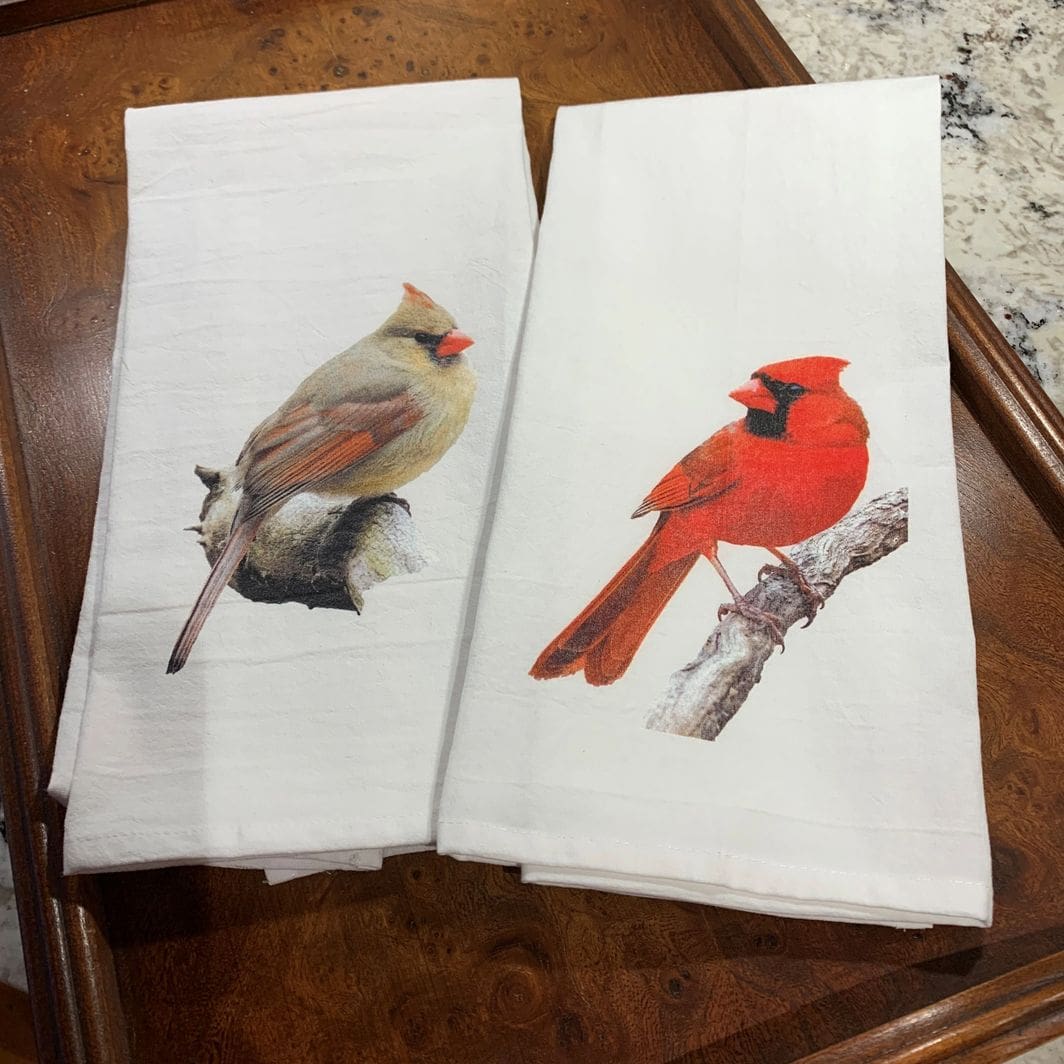 Two towels with a picture of birds on them.