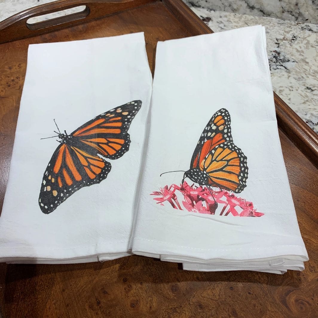 A pair of tea towels with butterflies on them.