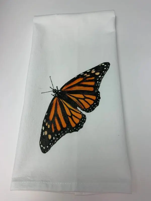 A butterfly is sitting on the white towel.