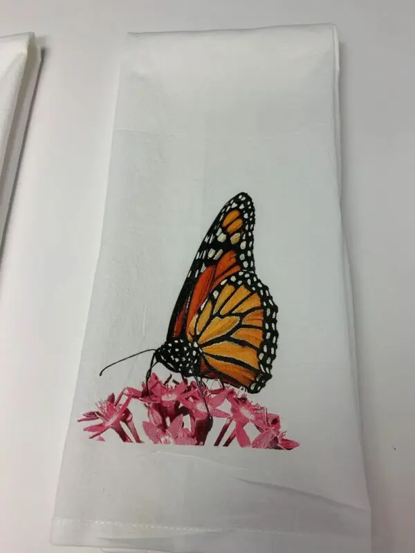 A butterfly sitting on top of pink flowers.