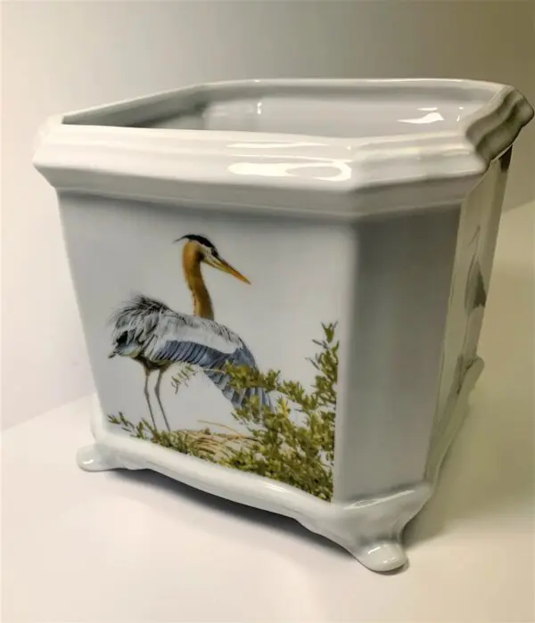 A white planter with an image of birds.